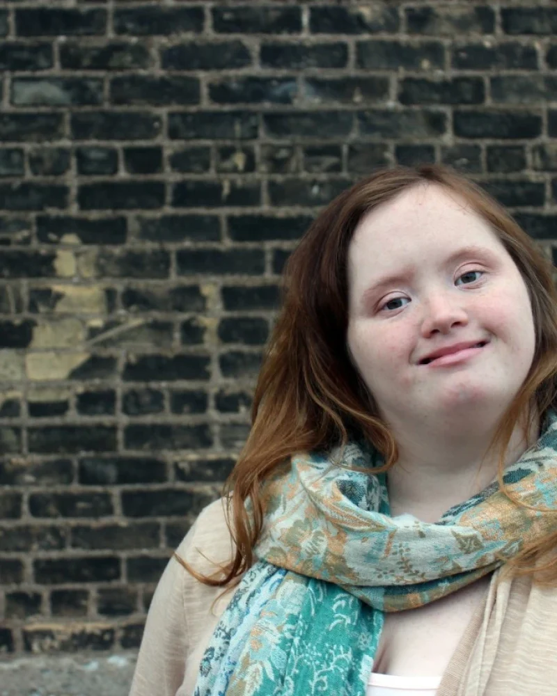 Girl with down syndrome smiling at camera